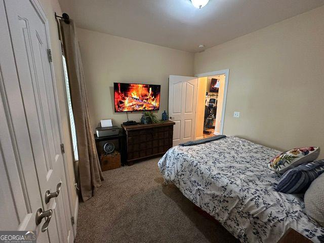 carpeted bedroom with a fireplace