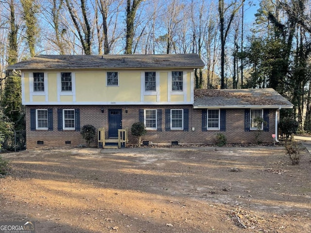 colonial house with entry steps, crawl space, brick siding, and stucco siding