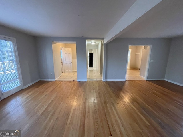 unfurnished living room with light wood finished floors and baseboards