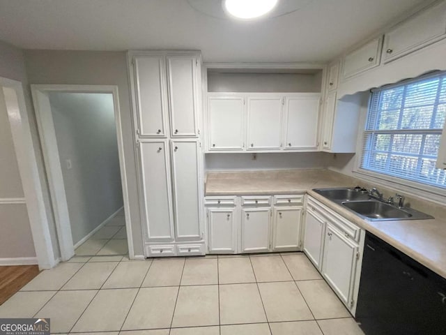 kitchen featuring light countertops, white cabinets, a sink, and dishwasher