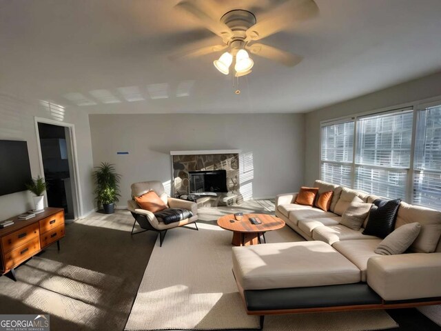 living room featuring a fireplace and ceiling fan