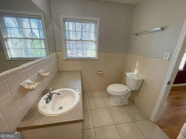 bathroom featuring toilet, tile patterned floors, a wainscoted wall, and vanity