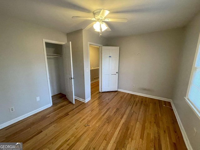 unfurnished bedroom featuring a closet, baseboards, and wood finished floors