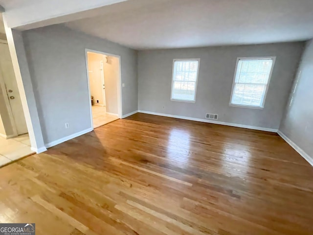 interior space with wood finished floors, visible vents, and baseboards