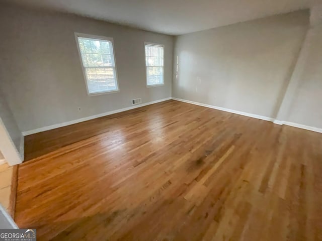 interior space with baseboards, visible vents, and wood finished floors