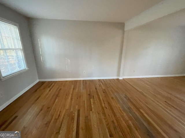 empty room with baseboards and wood finished floors