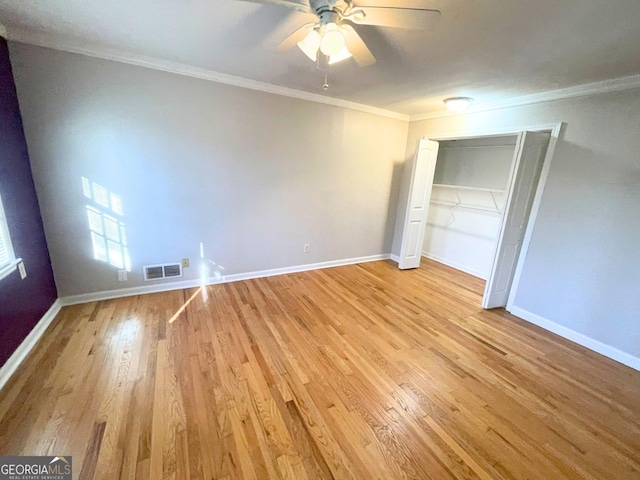 unfurnished bedroom featuring baseboards, light wood-type flooring, visible vents, and crown molding