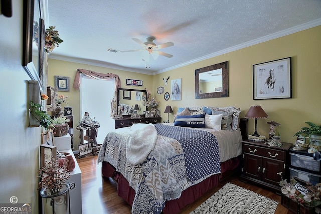 bedroom featuring ceiling fan, crown molding, wood-type flooring, and a textured ceiling