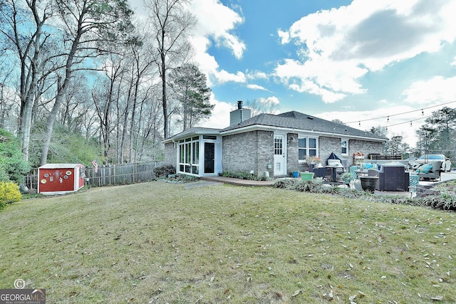 rear view of property featuring a sunroom, a yard, a patio area, and a shed