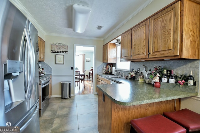 kitchen with tasteful backsplash, sink, stainless steel appliances, and kitchen peninsula