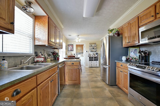 kitchen with sink, crown molding, stainless steel appliances, and decorative backsplash