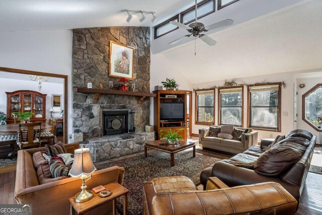 living room with hardwood / wood-style flooring, a stone fireplace, high vaulted ceiling, and ceiling fan