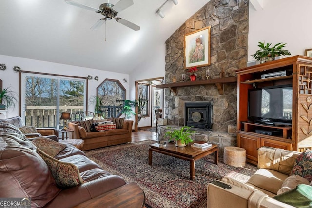 living room featuring a fireplace, high vaulted ceiling, rail lighting, wood-type flooring, and ceiling fan