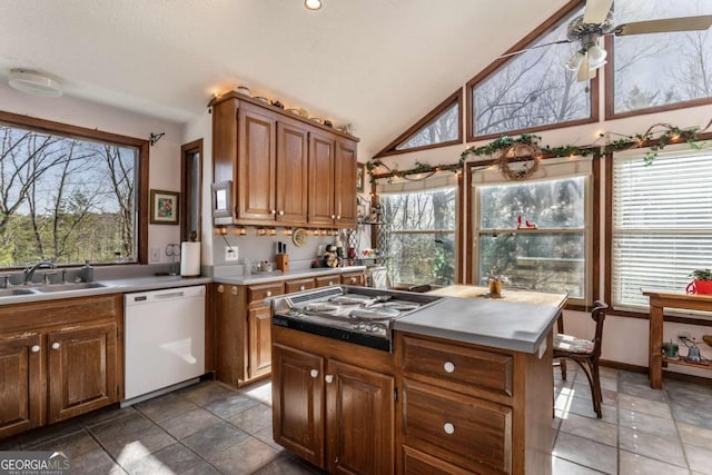 kitchen featuring stainless steel gas cooktop, sink, vaulted ceiling, dishwasher, and ceiling fan