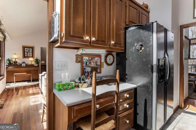 kitchen with stainless steel refrigerator with ice dispenser, lofted ceiling, and light hardwood / wood-style floors