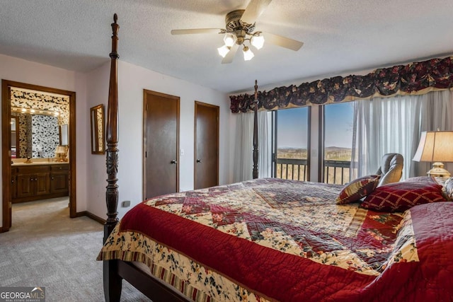 carpeted bedroom featuring connected bathroom, two closets, a textured ceiling, and ceiling fan