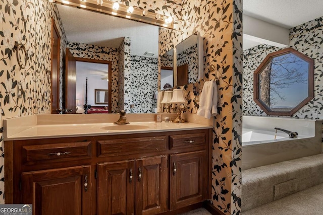 bathroom featuring vanity, a tub, and a textured ceiling