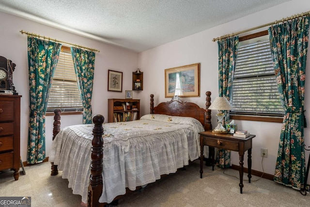 carpeted bedroom with multiple windows and a textured ceiling