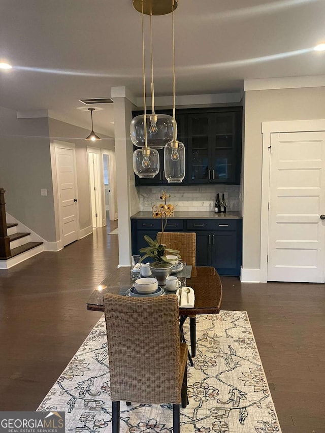 dining space featuring bar and dark hardwood / wood-style floors