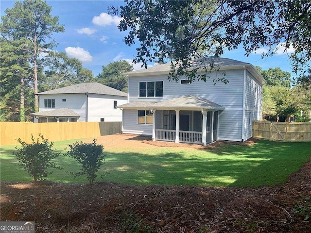 back of house with a yard and a sunroom