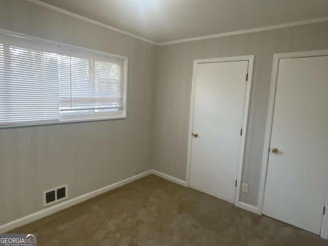 unfurnished bedroom with ornamental molding and carpet