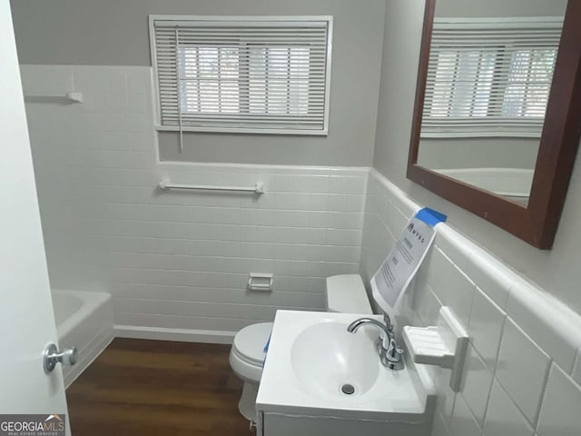 bathroom with hardwood / wood-style flooring, plenty of natural light, toilet, and vanity