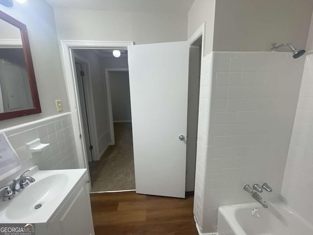 bathroom with vanity, wood-type flooring, bathing tub / shower combination, and tile walls