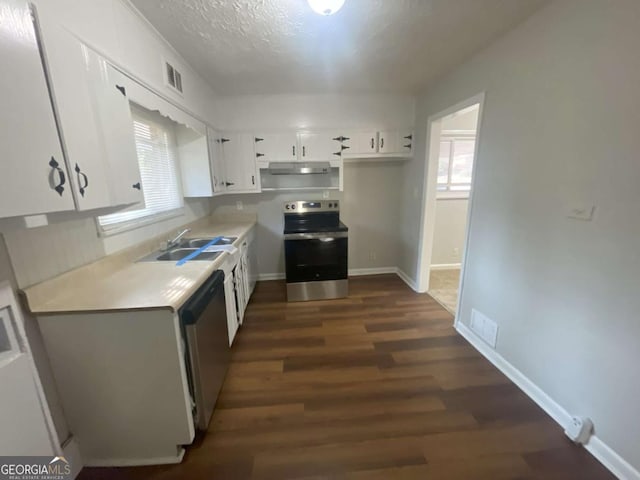 kitchen with sink, appliances with stainless steel finishes, white cabinetry, a textured ceiling, and dark hardwood / wood-style flooring