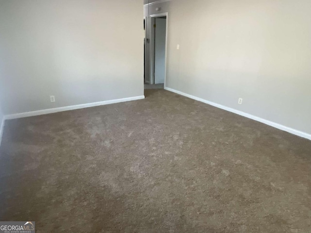 unfurnished room featuring dark carpet