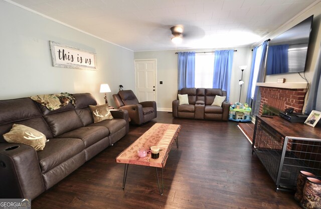 living room with dark hardwood / wood-style flooring, a brick fireplace, and ornamental molding