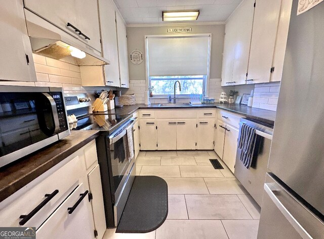 kitchen featuring light tile patterned floors, stainless steel appliances, sink, and white cabinets