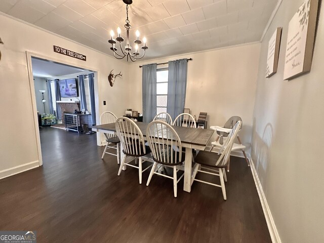 dining space featuring ornamental molding, a brick fireplace, dark hardwood / wood-style floors, and a chandelier