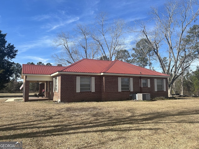 view of home's exterior featuring cooling unit and a lawn