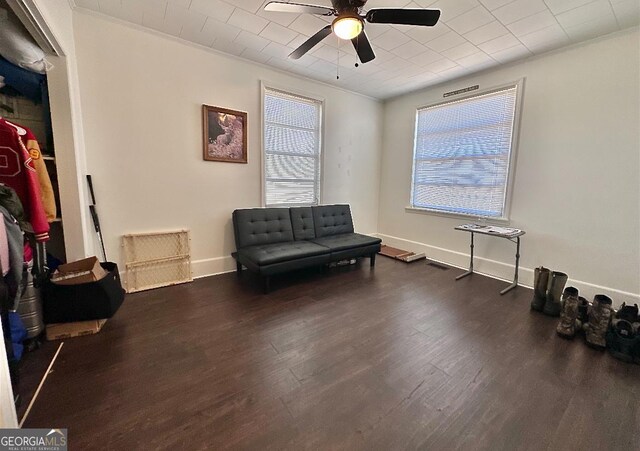 living area with ceiling fan, ornamental molding, and dark hardwood / wood-style floors