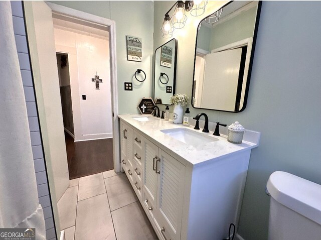 bathroom featuring vanity, toilet, and tile patterned flooring