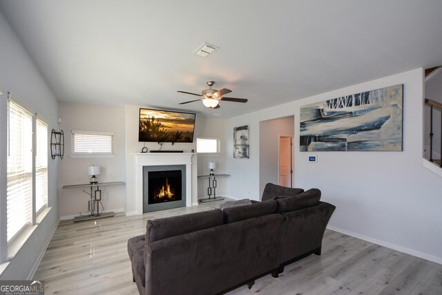 living room featuring light hardwood / wood-style flooring and ceiling fan