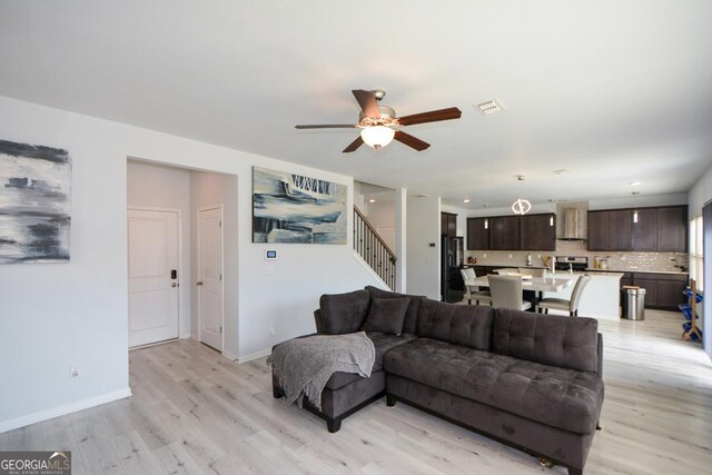 living room with ceiling fan and light wood-type flooring