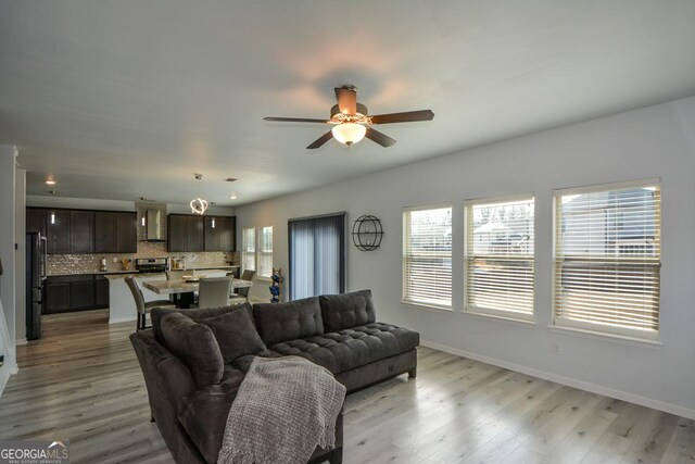 living room with ceiling fan and light wood-type flooring