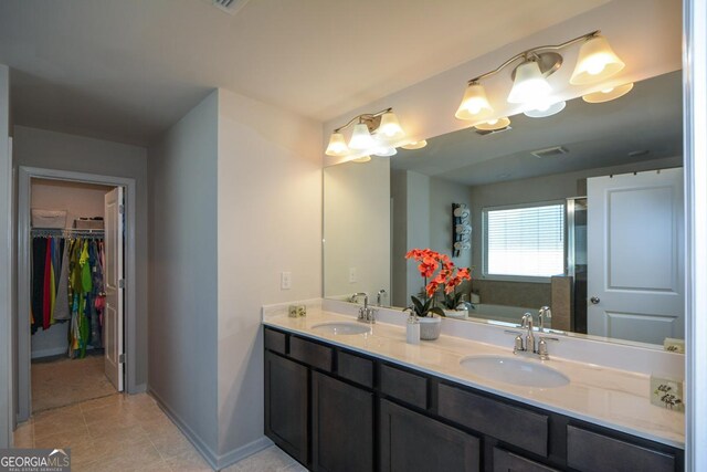 bathroom with tile patterned floors, vanity, and a washtub