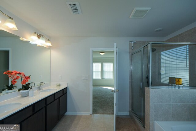 bathroom with tile patterned flooring, vanity, and separate shower and tub