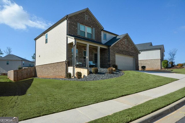 view of front facade with a garage, covered porch, and a front lawn