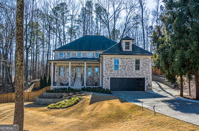 view of front of house with a garage, a front lawn, and a porch