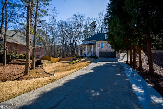 view of front of property featuring a garage, a front yard, and covered porch