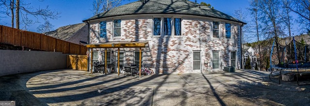 rear view of house with a patio area and a trampoline