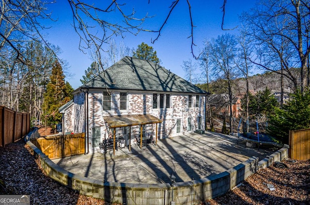 rear view of house featuring a patio and a trampoline