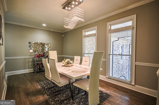 dining room with dark wood-type flooring, ornamental molding, and a notable chandelier