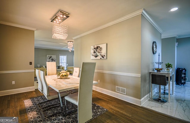 dining space with ornamental molding, dark hardwood / wood-style floors, and a chandelier