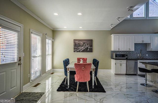 dining room with ornamental molding and sink