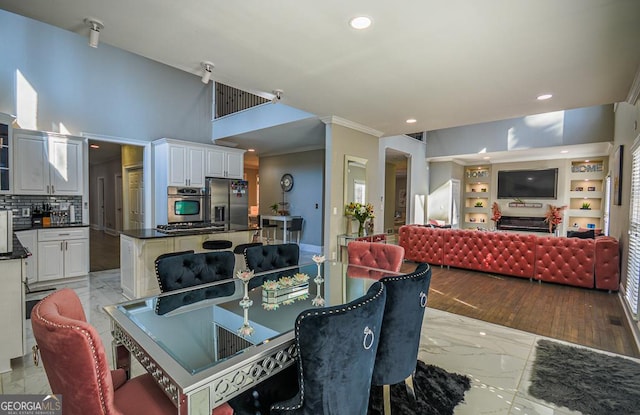 dining space featuring a high ceiling and ornamental molding