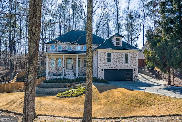 view of front facade featuring a garage, a front yard, and a porch